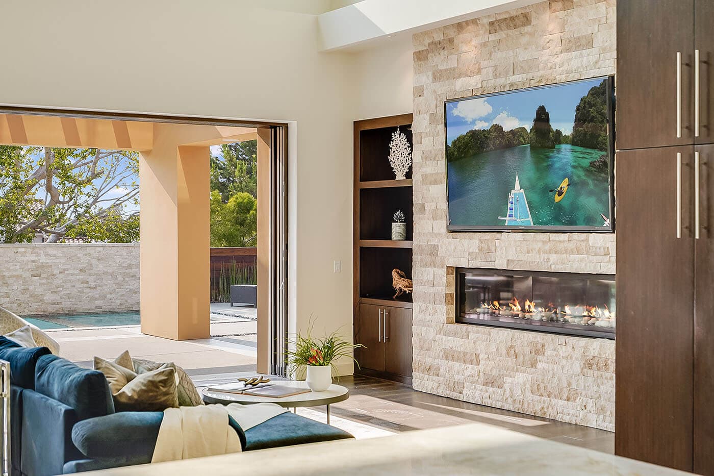 A stone fireplace wall opening to a patio, photographed by a member studio